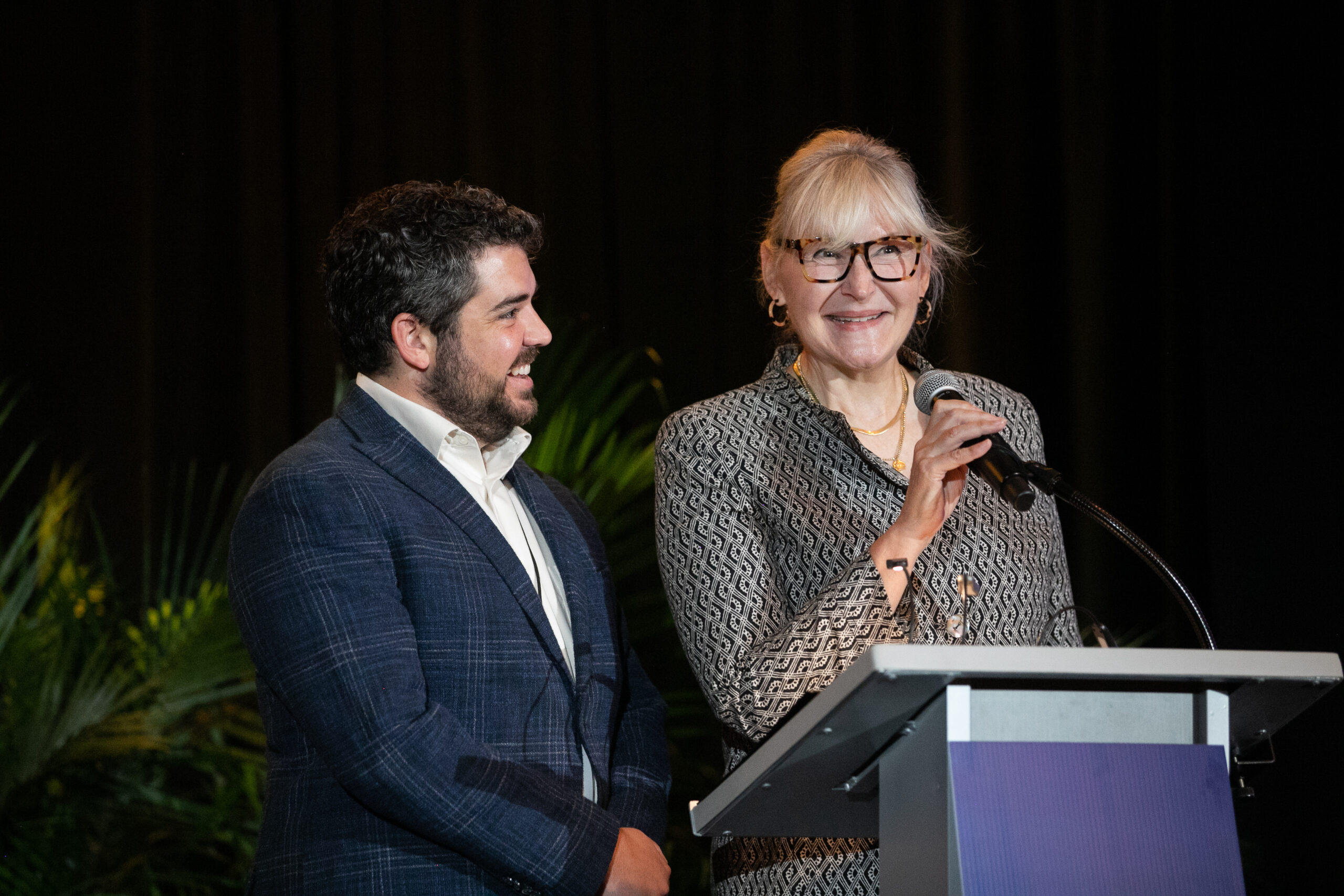 A woman and man speaking on stage