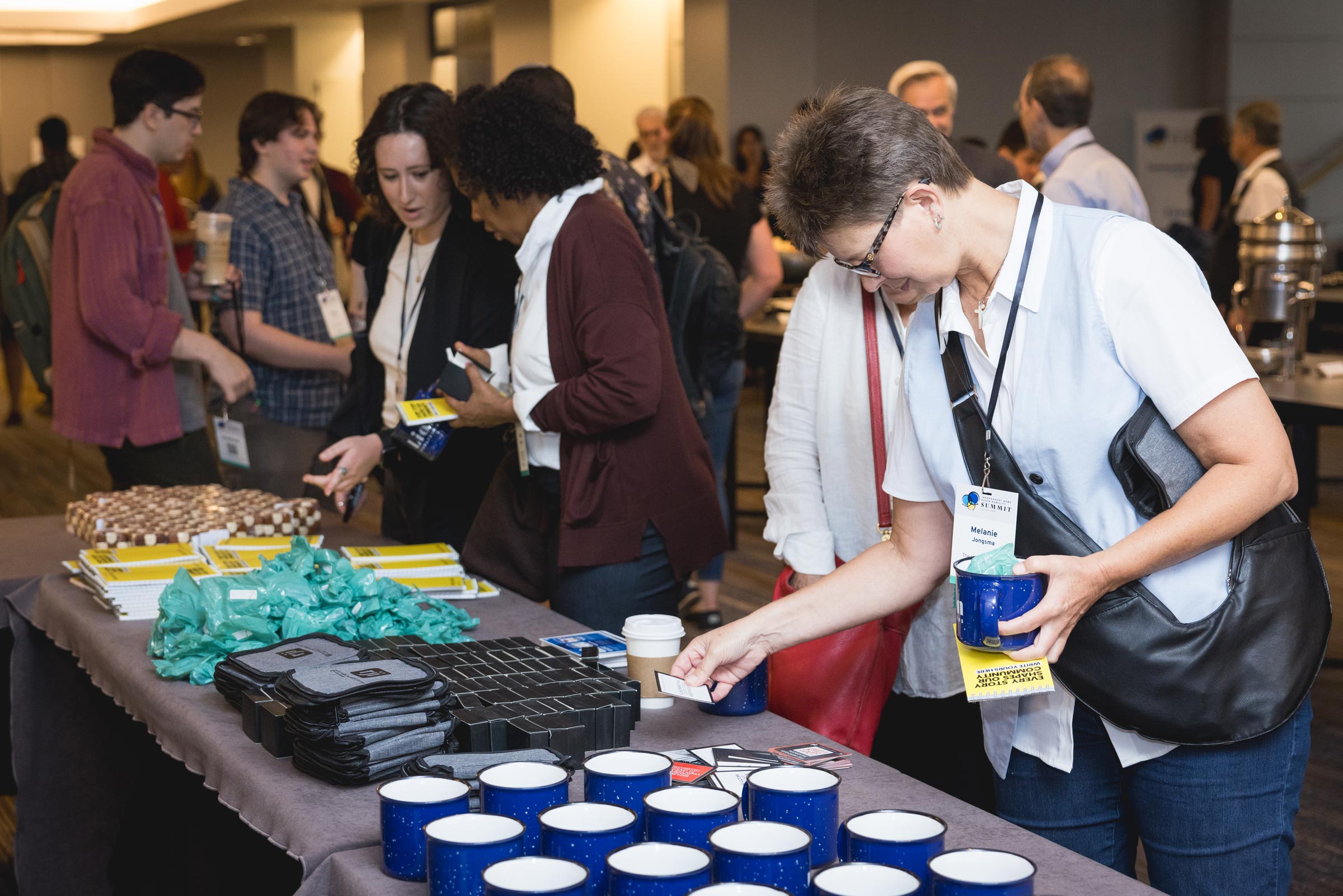 Attendees peruse sponsor swag at the 2024 Independent News Sustainability Summit. Photo by Fig Media.