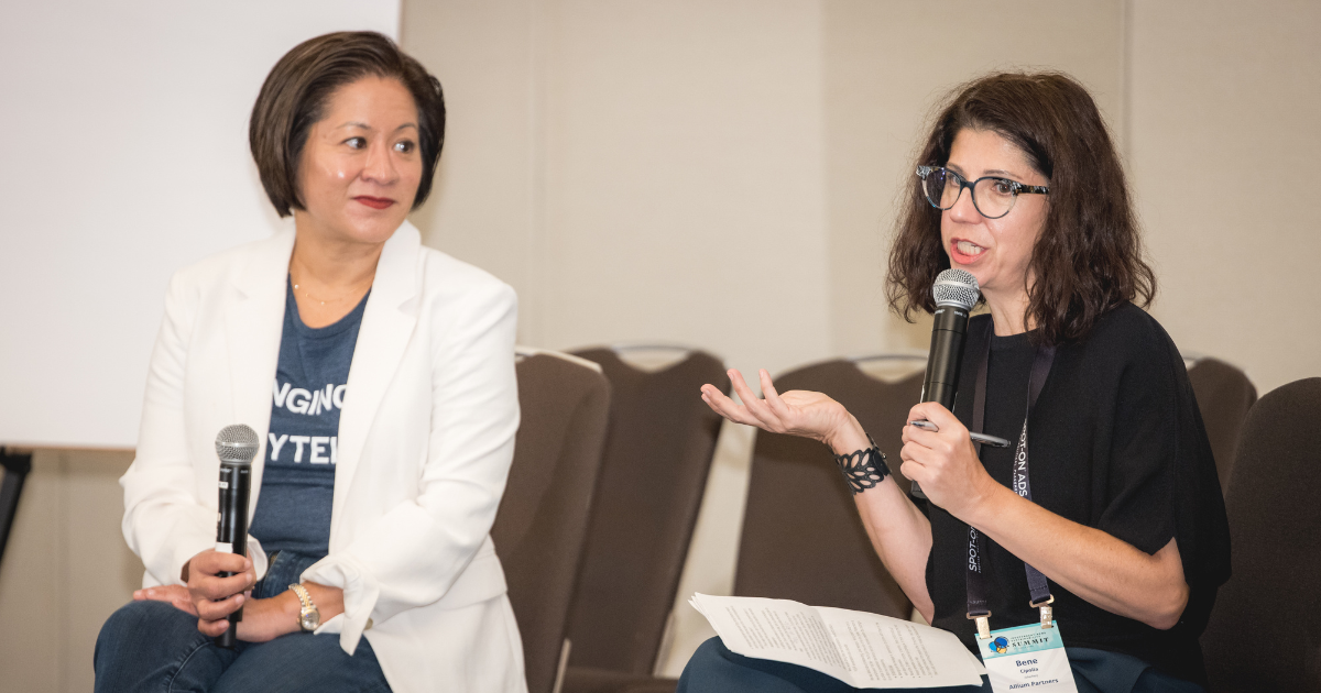 Two speakers on stage speaking